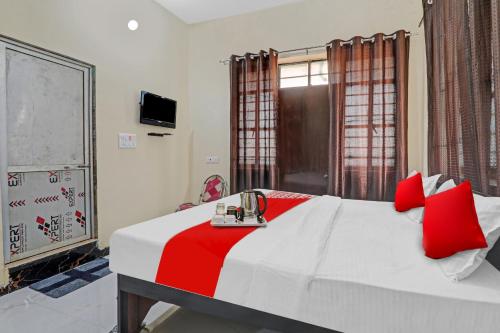 a bedroom with a large white bed with red pillows at OYO Flagship Hotel Sunrise Inn in Gorakhpur
