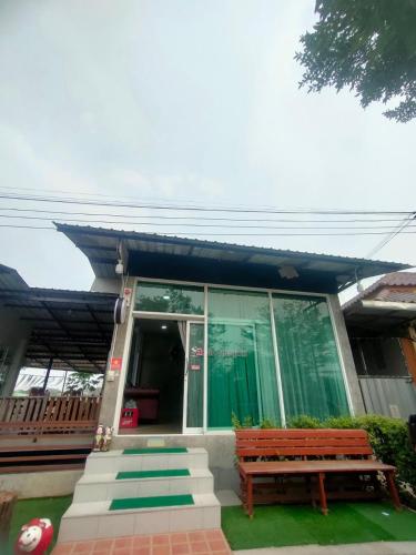 a house with a bench in front of it at Chatchawan Resort in Ban Tha Sao