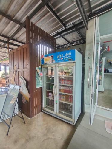 a store with a refrigerator with food inside of it at Chatchawan Resort in Ban Tha Sao