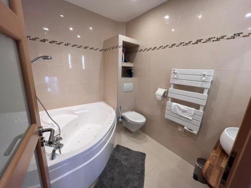 ein Badezimmer mit einer Badewanne, einem WC und einem Waschbecken in der Unterkunft Maison Climatisée 04 chambres Paris Disney CDG in Gagny