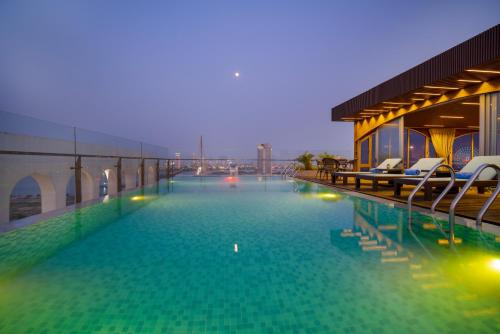 a large swimming pool with chairs on a building at Gold Plaza Hotel Da Nang in Da Nang