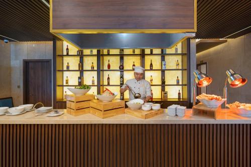a kitchen with a chef standing behind a counter at Gold Plaza Hotel Da Nang in Da Nang