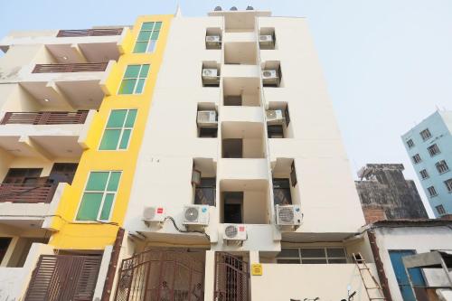 a tall white building with windows and balconies at Hotel O A P Residency in Noida