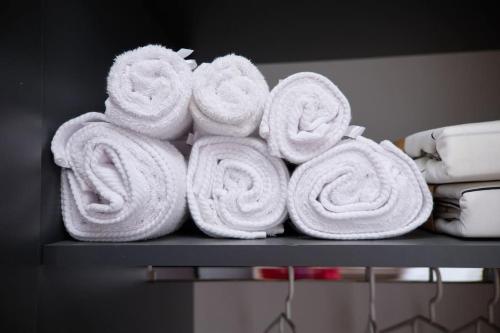 um monte de toalhas estão empilhadas numa prateleira em City Center Accommodation - 410 em Reşiţa