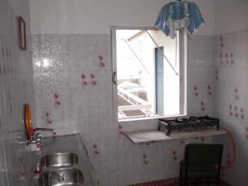 eine Küche mit einem Waschbecken und einem Fenster darin in der Unterkunft Pension Gina in Methana