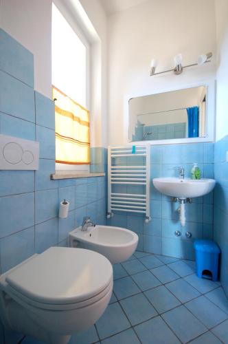a blue bathroom with a toilet and a sink at Casa Balena Bianca in Lacona