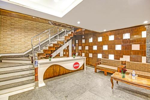 a lobby with stairs and a bench and a table at Flagship Hotel Starwood in Jammu