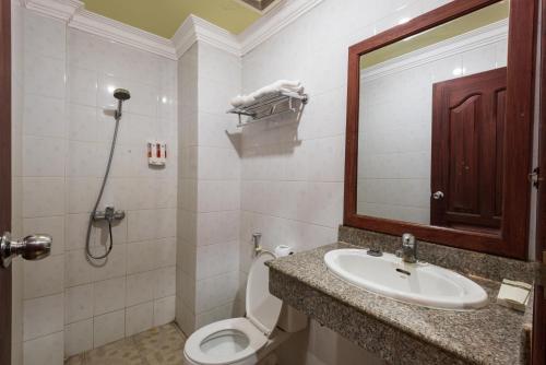 a bathroom with a sink and a toilet and a mirror at Sihariddh BnB Villa in Siem Reap