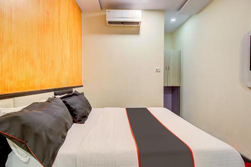 - une chambre avec un lit et une armoire en bois dans l'établissement Golden Tulipz Boutique, à Mumbai