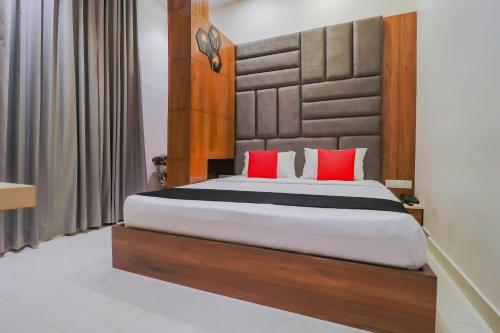 a bedroom with a large bed with red pillows at Capital O Western Galaxy in Amritsar