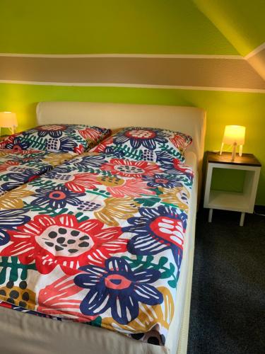 a bedroom with a bed with a colorful comforter at Hotel Zur Schleuse (Garni) in Datteln