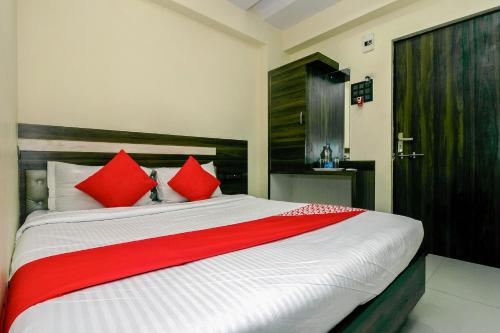 - une chambre avec un grand lit et des oreillers rouges dans l'établissement OYO Parimeet Hotel, à Turambhe