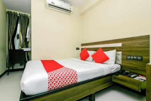 - une chambre avec un lit doté d'oreillers rouges et blancs dans l'établissement OYO Parimeet Hotel, à Turambhe