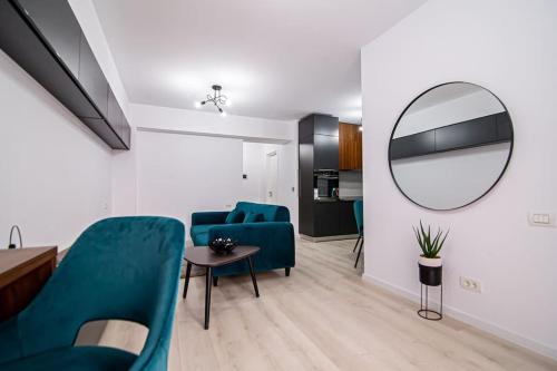 - un salon avec des chaises bleues et un miroir dans l'établissement City Center Accomodation- 401, à Reşiţa