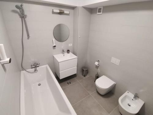 La salle de bains est pourvue d'une baignoire, de toilettes et d'un lavabo. dans l'établissement City Center Accomodation- 401, à Reşiţa