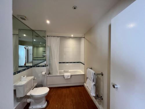 a bathroom with a toilet and a bath tub at Brook Mollington Banastre Hotel & Spa in Chester