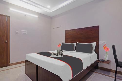 um quarto com uma cama grande e uma cabeceira em madeira em Srinika Inn em Hyderabad