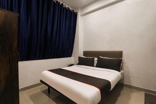 Insight Inn Near Gomti Riverfront Park في Vibhuti Khand: غرفة نوم بسرير كبير مع نافذة زرقاء