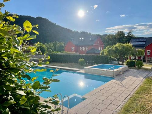 a swimming pool in a yard with a house at Hotelpark Bodetal mit Ferienwohnungen in Thale