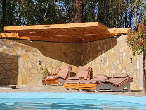 um grupo de cadeiras sentadas ao lado de uma piscina em Villa Stefania em Ágios Ioánnis