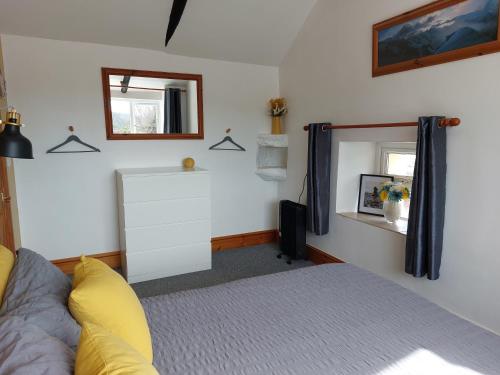 a bedroom with a bed and a mirror at The Barn - Cosy cottage with Countryside views in Ludchurch