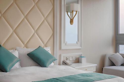 a bedroom with a bed and a chair and a window at Wuhu Suning Universal Hotel in Wuhu