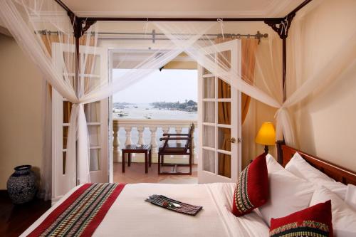 sypialnia z łóżkiem i widokiem na ocean w obiekcie Victoria Chau Doc Hotel w mieście Châu Đốc