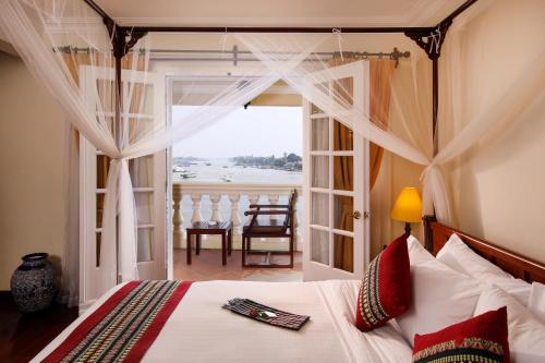 a bedroom with a bed with a view of the ocean at Victoria Chau Doc Hotel in Chau Doc