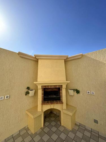 a room with a fireplace in the side of a building at Lovely 3 Bedrooms Fully Equipped With Central Ac in Rejiche