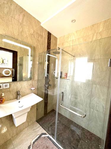 a bathroom with a shower and a sink at Lovely 3 Bedrooms Fully Equipped With Central Ac in Rejiche