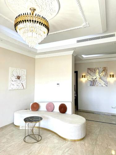 a bedroom with a large white bed with a chandelier at Lovely 3 Bedrooms Fully Equipped With Central Ac in Rejiche