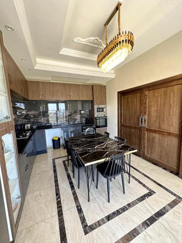 a large kitchen with a table and chairs in it at Lovely 3 Bedrooms Fully Equipped With Central Ac in Rejiche