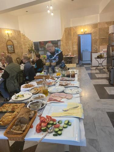 a long table full of food with people sitting around it at Costas Inn in Spílion