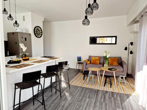 une cuisine et un salon avec un canapé et une table dans l'établissement Nice Charmant 3 pièces proche mer Parking, à Nice