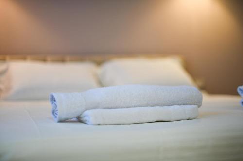 a stack of towels sitting on top of a bed at Nicolaus Hidden Gem Villa in Shkodër