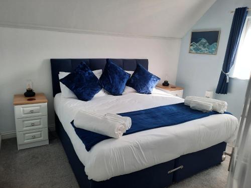 a bedroom with a large bed with blue pillows at Captain's Lodge in Sandown