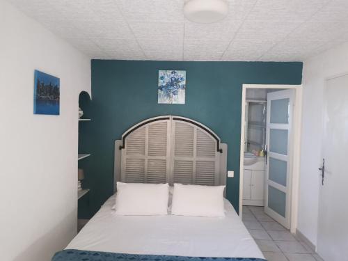 - une chambre dotée d'un lit avec un mur bleu dans l'établissement La Bastide des Cades, à Aiguines
