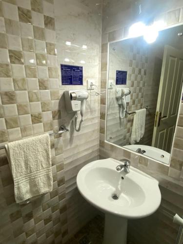 a bathroom with a sink and a mirror at TETE PALM HOTEL in Vila-de-Santiago-Maior