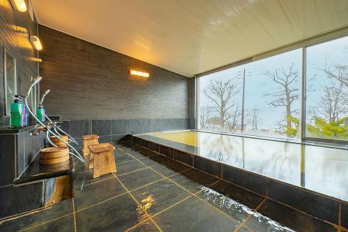 a room with a swimming pool with a large window at Lake Toya Villa SUSUKIAN in Sobetsu