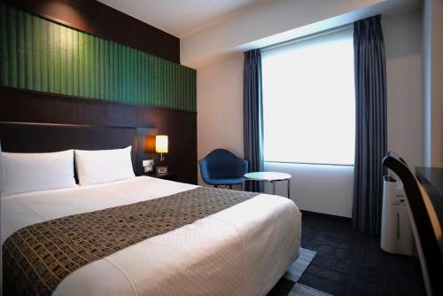 Hotel Bestland في تسوكوبا: غرفه فندقيه بسرير ونافذه