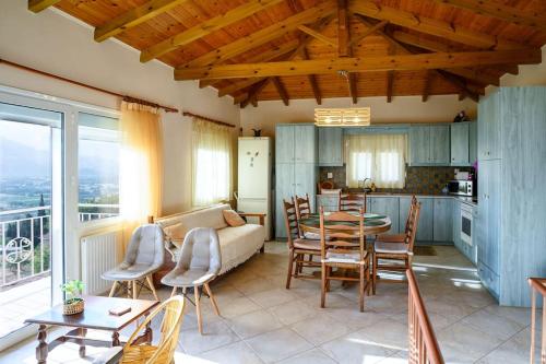 a living room with a couch and a table and chairs at Σπίτι με Τζάκι & Θέα in Mesinón