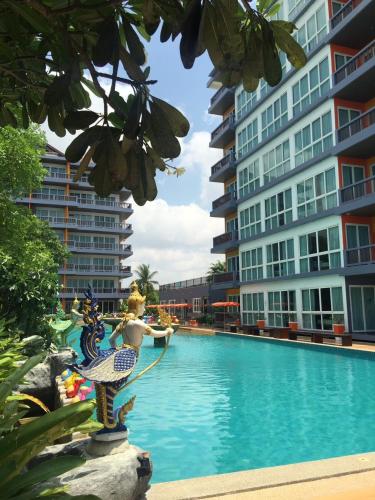 a mermaid statue next to a swimming pool in a building at The Sand Beach Pattaya in Na Jomtien