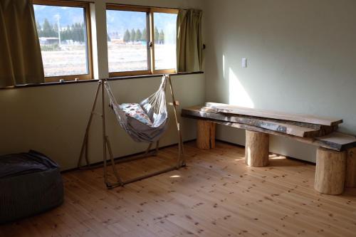 安曇野市にあるAzumino Fukuro Guesthouse - Vacation STAY 21913vのハンモック、テーブル、窓が備わる客室です。