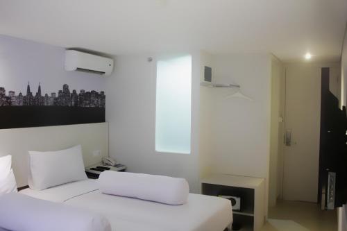 a bedroom with two white beds and a window at Vio Cihampelas in Bandung