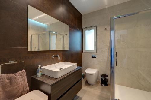 a bathroom with a sink and a toilet and a shower at Luxury Penthouse with Terrace and Views in St Julian's