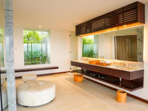 een badkamer met een grote wastafel en een grote spiegel bij Jeeva Mandalika in Kuta Lombok