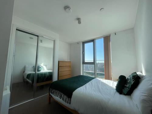 a bedroom with a bed and a large window at Nottingham City Centre Apartment in Nottingham