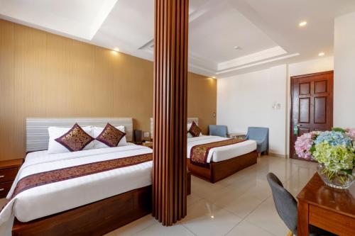 a hotel room with two beds and a desk at Airport Saigon Hotel - Gần ẩm thực đêm chợ Phạm Văn Hai in Ho Chi Minh City