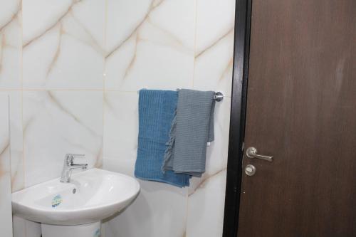 a bathroom with a white sink and a blue towel at Samarah Dead Sea Resort Apartment with Sea View FP4 Traveler Award 2024 Winner in Sowayma