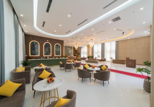 a lobby of a hotel with tables and chairs at Grand Tourane Nha Trang Hotel in Nha Trang